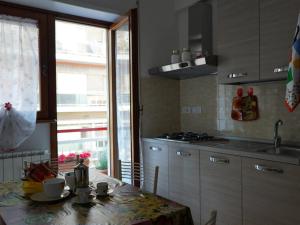 a kitchen with a table and a sink and a window at Casa Vacanze 2 bedrooms DIMORA DEL VIANDANTE in Civitavecchia