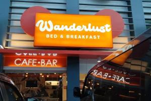 公主港Wanderlust Bed and Breakfast Puerto Princesa的餐厅前的标志