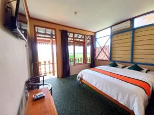 une chambre avec un lit, une table et des fenêtres dans l'établissement Hotel Syariah Simply Homy dekat Yogyakarta International Airport, à Glagah