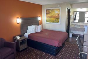 a hotel room with a bed and a chair at Days Inn by Wyndham El Reno in El Reno