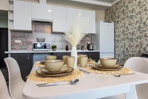 a white table with plates and cups on it in a kitchen at Ушсункар Nice in Almaty