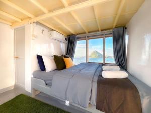 une chambre avec un grand lit avec une grande fenêtre dans l'établissement KLM Senayla, à Labuan Bajo