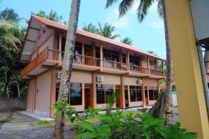 un immeuble de villégiature avec un balcon et des palmiers dans l'établissement Hotel Syariah Simply Homy dekat Yogyakarta International Airport, à Glagah