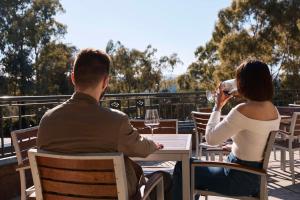 a man and woman sitting at a table drinking wine at Yarra Valley Lodge in Wonga Park