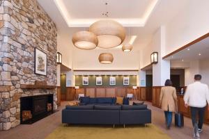 two people walking through a lobby with a stone fireplace at Yarra Valley Lodge in Wonga Park
