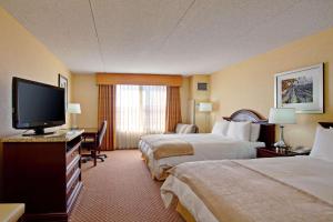 a hotel room with two beds and a flat screen tv at Radisson Hotel Santa Maria in Santa Maria +35 photos