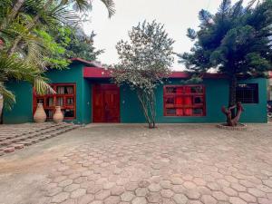 a green and red building with palm trees in front of it at Villa Jacalón - Beautiful home colonial style in Viguera