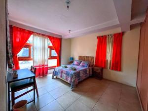 a bedroom with red curtains and a bed and a desk at Villa Jacalón - Beautiful home colonial style in Viguera
