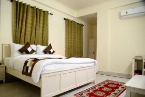 a bedroom with a white bed and green curtains at Hotel Dior Near Jal Mahal, Jaipur in Jaipur