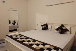 a large bed in a room with a checkeredkered at Hotel Dior Near Jal Mahal, Jaipur in Jaipur