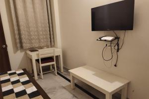 a room with a tv on the wall and a table at Hotel Dior Near Jal Mahal, Jaipur in Jaipur