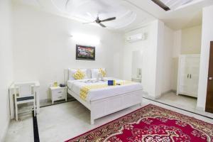 a white bedroom with a white bed and a red rug at Hotel Dior Near Jal Mahal, Jaipur in Jaipur
