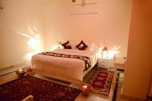 a bedroom with a large bed and a red rug at Hotel Dior Near Jal Mahal, Jaipur in Jaipur