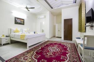 a bedroom with a white bed and a red rug at Hotel Dior Near Jal Mahal, Jaipur in Jaipur