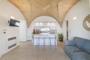 Una sala de estar con un sofá y una cocina. en VILLA FLORI', en Marina di Pescoluse