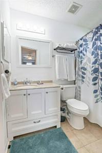 un bagno bianco con un water e un lavandino di Surfside Cottage - Charming Quiet 3BD 2BA House - Private Beach Access, Close to Navarre Beach & Gulf Breeze Zoo a Gulf Breeze