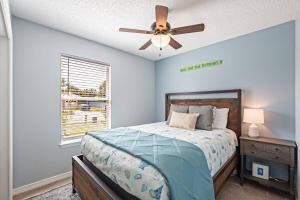 una camera da letto con un letto e un ventilatore a soffitto di Surfside Cottage - Charming Quiet 3BD 2BA House - Private Beach Access, Close to Navarre Beach & Gulf Breeze Zoo a Gulf Breeze