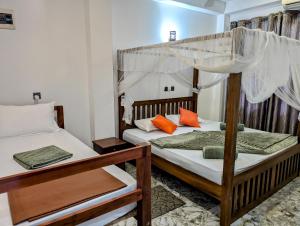 a bedroom with two bunk beds with orange pillows at Costels Mirissa in Mirissa