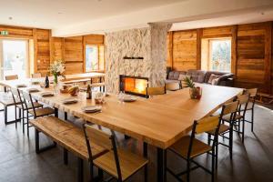 a large wooden table in a room with a fireplace at chalet la forgerie Piscine Jacuzzi Cinéma in La Forge