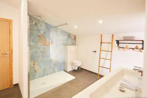 a bathroom with a tub and a toilet and a sink at chalet la forgerie Piscine Jacuzzi Cinéma in La Forge +21 photos