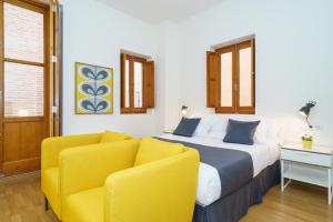 sypialnia z łóżkiem i żółtym krzesłem w obiekcie Valencia Home w Walencji