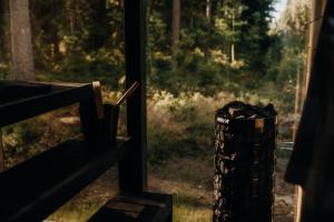 a window with a trash can next to a forest at Mustika Mirror minivilla saunaga in Kärdla
