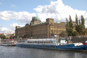 two boats in the water in front of a large building at Apartmany Chodov in Prague
