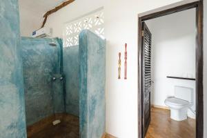 a bathroom with a shower and a toilet at Sunshine Bay Zanzibar - Adults Only in Matemwe