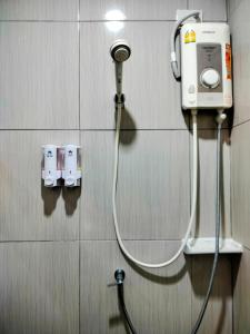 a hose hooked up to a shower in a bathroom at MikaHouse in Betong +17 photos