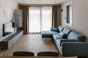 a living room with a blue couch and a tv at Residence Piccolo Olimpo in Toscolano Maderno