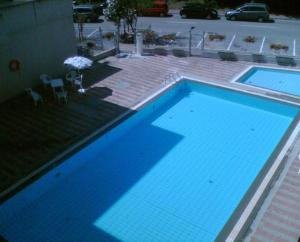 a large blue swimming pool next to a building at Beautifully renovated flat with shared pool in Rosolina Mare