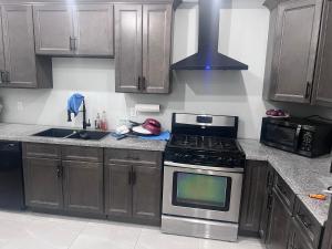 a kitchen with wooden cabinets and a stove top oven at Private Bathroom Room In Cambridge B7 in Cambridge +4 photos