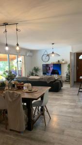 un soggiorno con un tavolo e un divano di Villa en bordure de colline*piscine*clim*netflix a Les Matelles