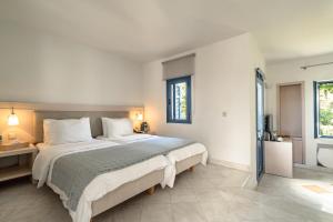 a bedroom with a large bed and a bathroom at Porto Galini Seaside Resort & Spa in Nikiana