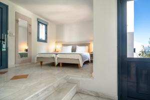 a bedroom with a bed and a large window at Porto Galini Seaside Resort & Spa in Nikiana
