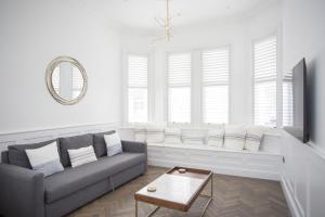 ein Wohnzimmer mit Sofa und Tisch in der Unterkunft Coachman's Cottage- Worthing Beach sleeps 9 in Worthing