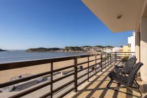 two chairs on a balcony looking out at the beach at Beachfront 3bdr apt on Marginal Boulevard in São Martinho do Porto
