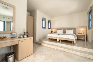 a bedroom with a large bed with white pillows at Porto Galini Seaside Resort & Spa in Nikiana