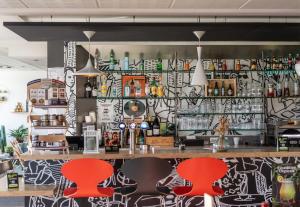 a bar with two red chairs in a restaurant at B&B HOTEL Limoges 3 in Limoges +19 photos