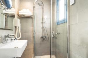 a bathroom with a shower and a sink at Porto Galini Seaside Resort & Spa in Nikiana