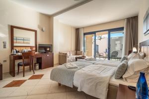 a bedroom with a large bed and a living room at Porto Galini Seaside Resort & Spa in Nikiana