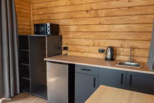 una cocina con fregadero y refrigerador en Будиночок з панорамою на річку, en Kudashevka 5 fotos más