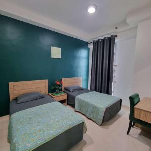 two beds in a room with blue walls at Kelantan Trade Centre in Kota Bharu