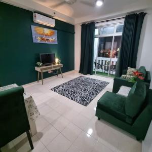 a living room with a green wall and a green couch at Kelantan Trade Centre in Kota Bharu