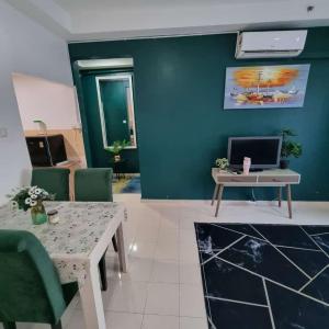 a living room with a blue wall and a table at Kelantan Trade Centre in Kota Bharu