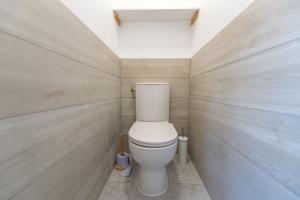 a bathroom with a toilet in a room with wooden walls at Baiona - Maison - Extérieur in La Grand Croix +14 photos