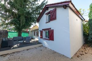 a white house with chairs and a patio at Baiona - Maison - Extérieur in La Grand Croix