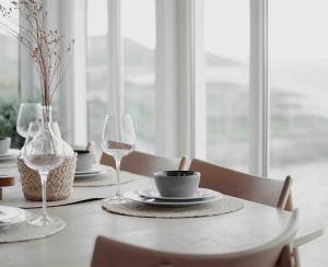 a table with two wine glasses and a bowl and a plate at Paradise by the Seaside in Hitra