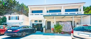a white house with cars parked in front of it at Apartments Dreamland in Baška