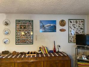 a room with a wooden cabinet and pictures on the wall at Baita vacanze Foppa in Rasura